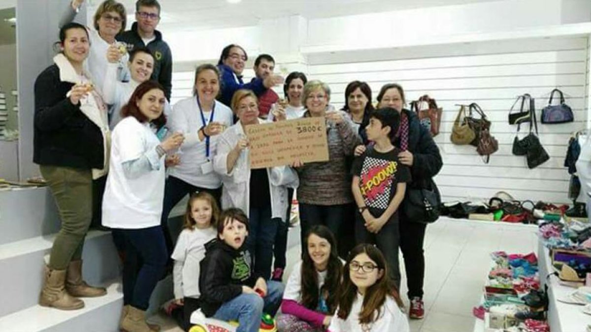 Miembros de la asociación brindan en un mercadillo solidario que la entidad hizo para conseguir una silla ortopédica.-ECB