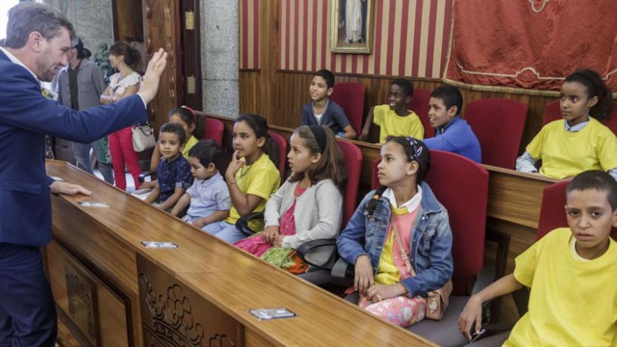 Los niños saharauis sentados en el salón de plenos del Ayuntamiento mientras el alcalde, Javier Lacalle, les saluda.-SANTI OTERO
