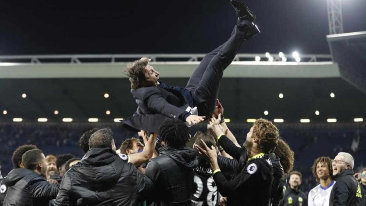 Antonio Conte, manteado por sus jugadores del Chelsea.-REUTERS