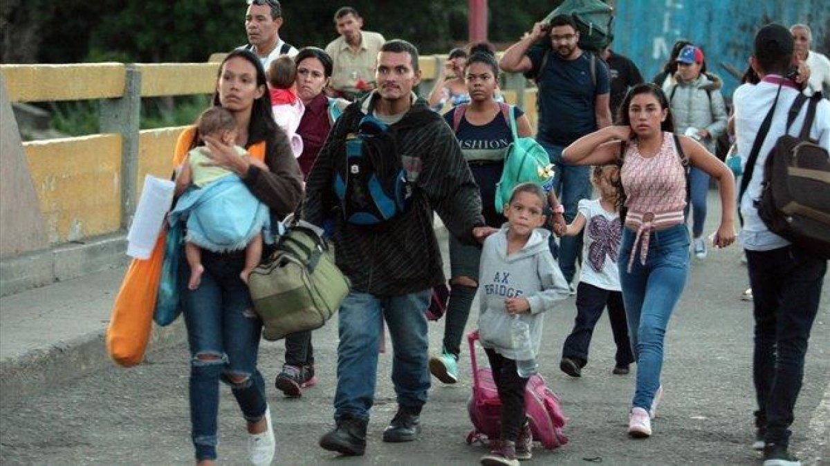 Una familia de inmigrantes venezolana pasa hacia Colombia  por el Puente Internacional Simon Bolivar.-EFE
