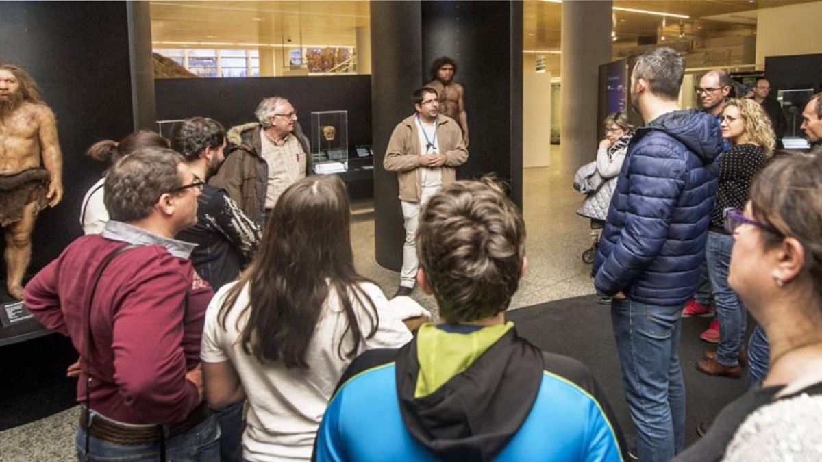 Un grupo de visitantes atiende a la explicación de uno de los guías del Museo de la Evolución Humana.-ISRAEL L. MURILLO