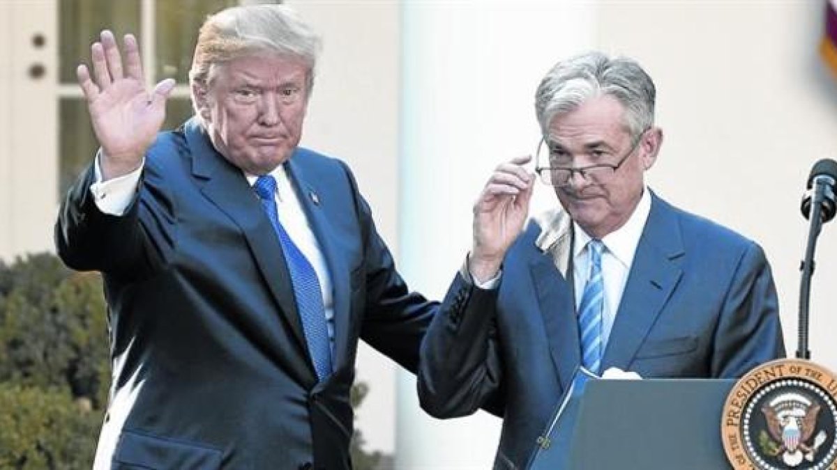 Donald Trump saluda junto a Jerome Powell, en su presentación como presidente de la Reserva Federal de Estados Unidos.-AFP / SAUL LOEB