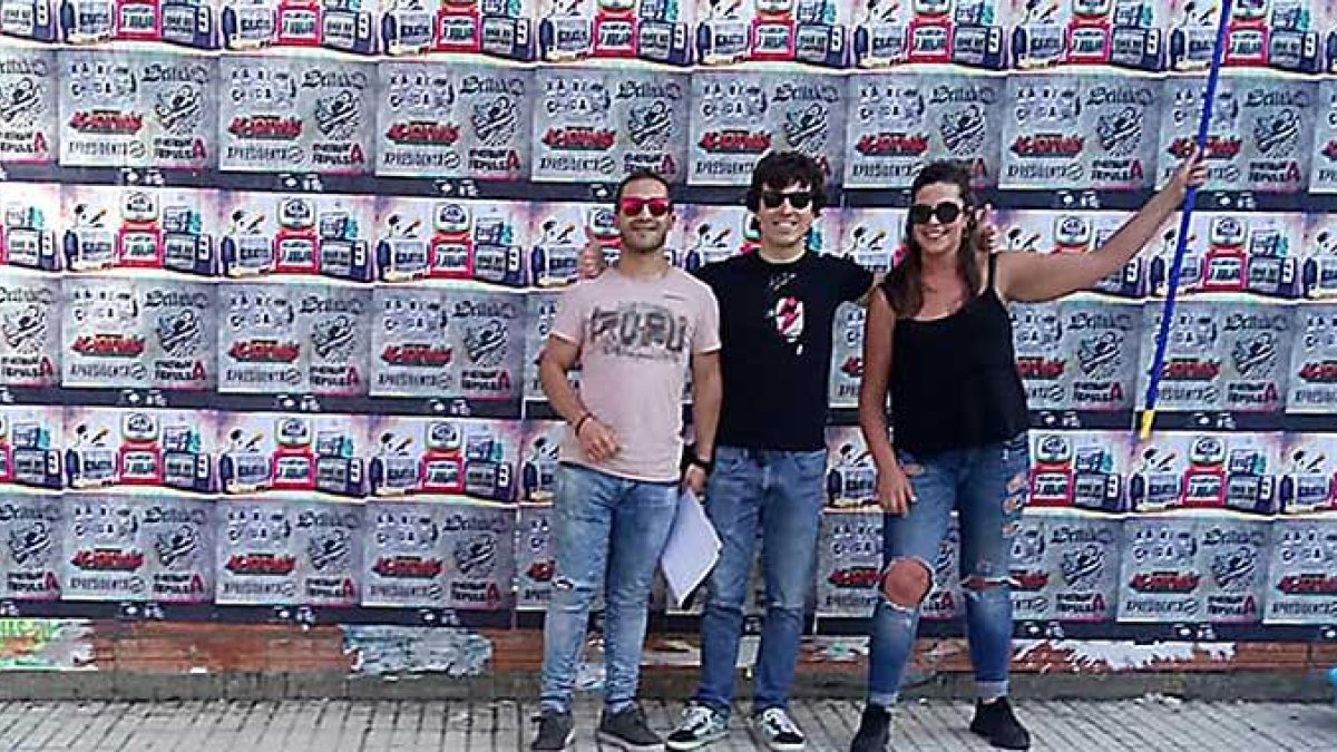 Tres de los organizadores del festival posan sonrientes tras una de sus tradicionales pegadas de carteles en Villarcayo.-DOLMEN MUSIC FEST