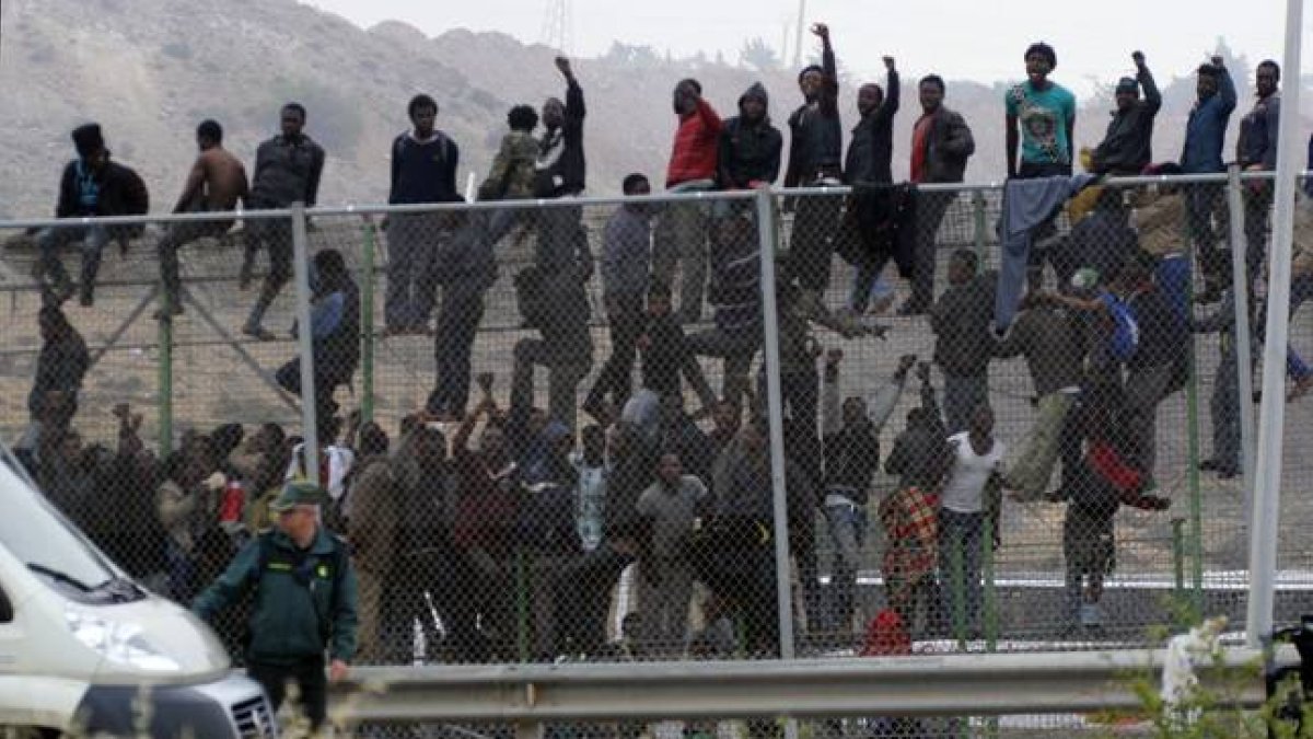 Inmigrantes subsaharianos encaramados a la valla de Melilla.-Foto: EFE / PACO GUERRERO