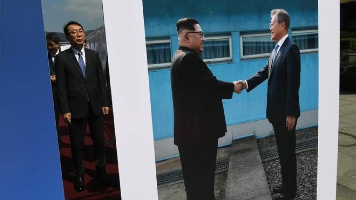 Un alto funcionario surcoreano observa una foto del presidente de Corea del Sur, Moon Jae-in, y del de Corea del Norte, Kim Jong-un, expuesta en Pyongyang.-AFP