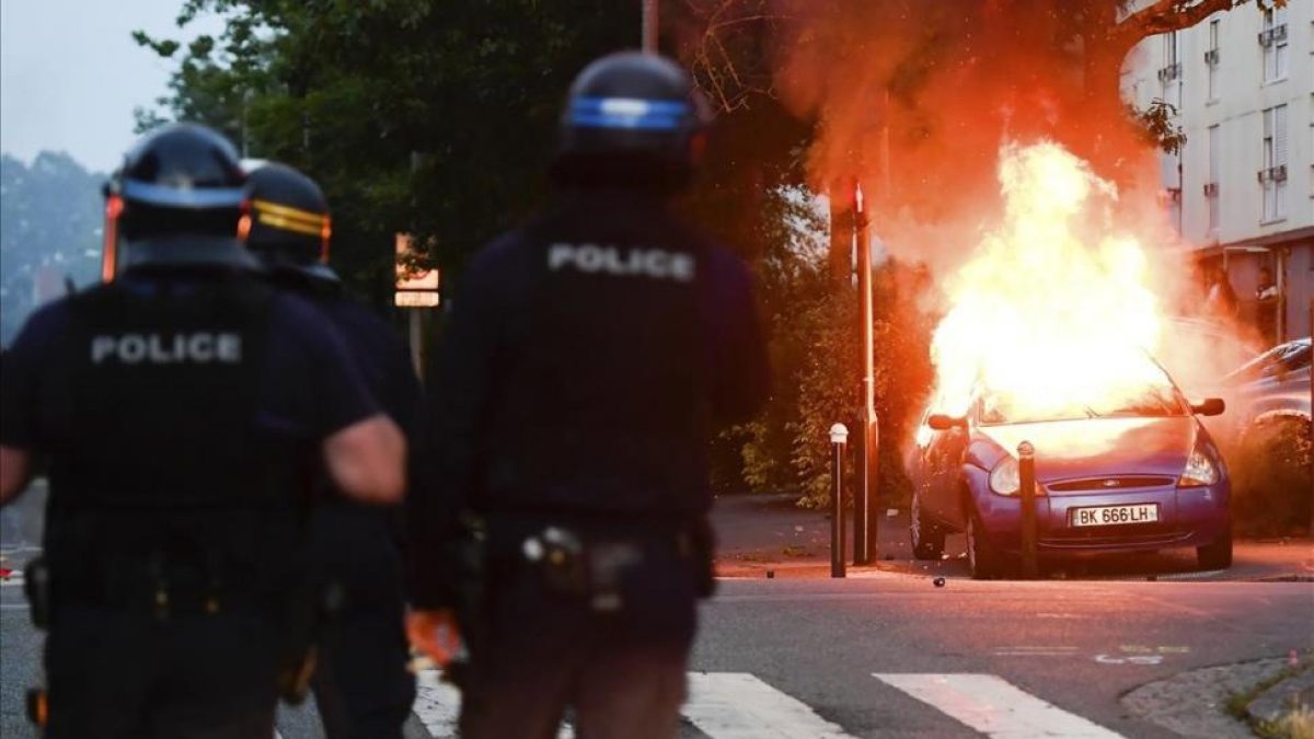 Varios policías ante un coche ardiendo, en Nantes.-/ AP / FRANCK DUBRAY
