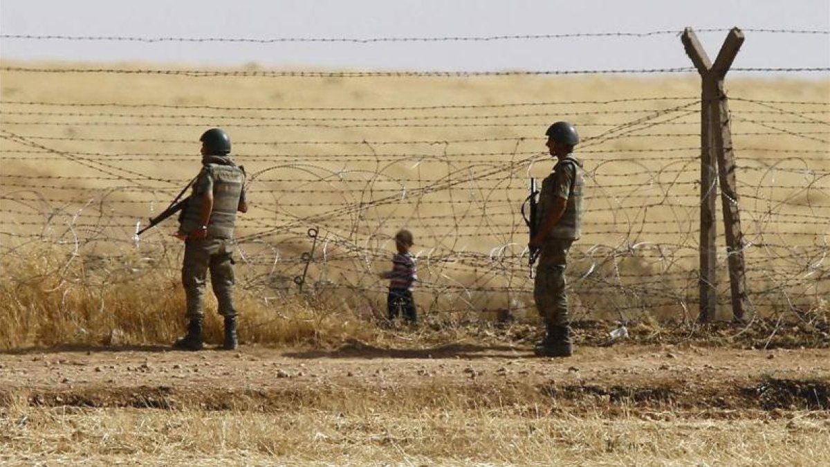 Un niño sirio espera tras las vallas de la frontera para cruzar hacia Turquía cerca de Akcacale (sureste), en el 2015.-REUTERS / OSMAN ORSAL