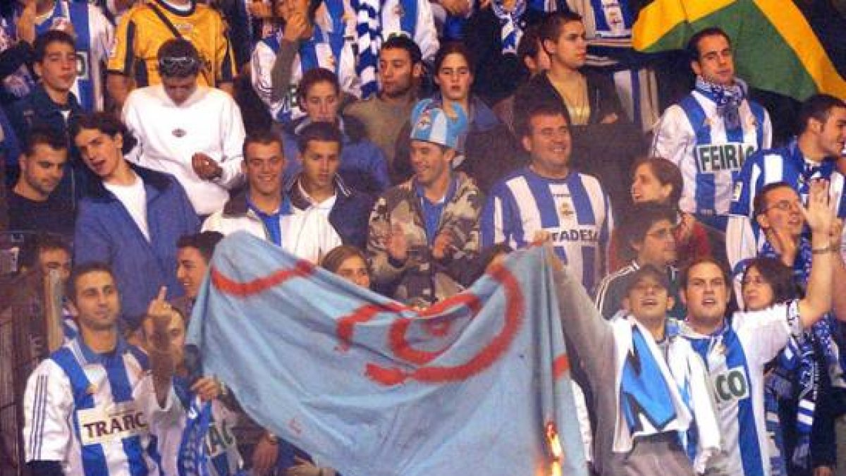 Aficionados del grupo radical Riazor Blues queman una bandera durante un partido, en octubre del 2003.-Foto: ARCHIVO / EFE