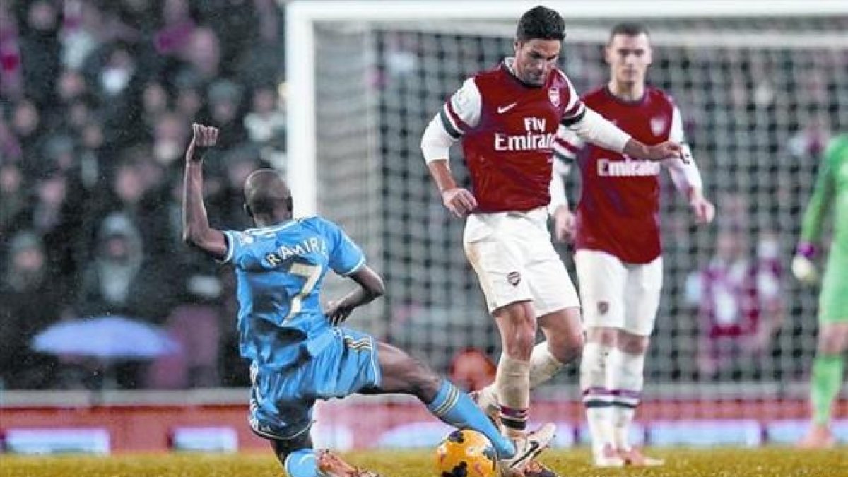 Dureza 8 Obi Mikel, centrocampista del Chelsea, hace una entrada a Arteta, jugador del Arsenal, el lunes en el duelo disputado en el Emirates.-REUTERS / ANDREW WINNING