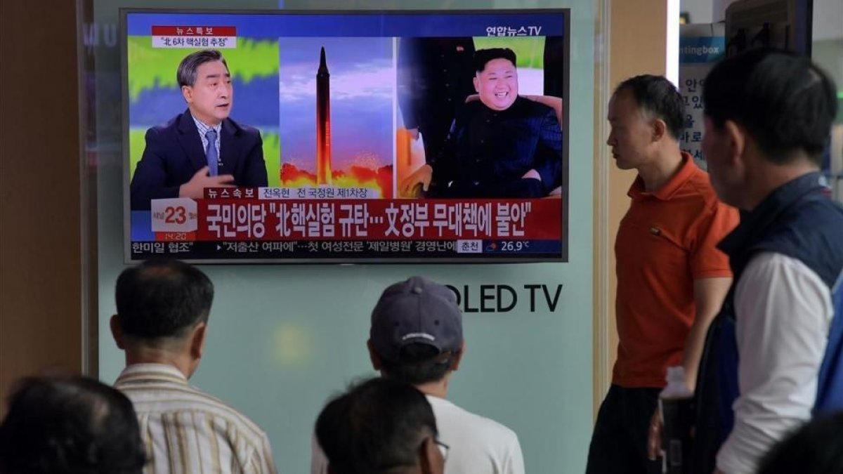 Ciudadanos surcoreanos siguen la noticia del ensayo nuclear de Corea del Norte en una estación de Seúl.-AFP / ED JONES