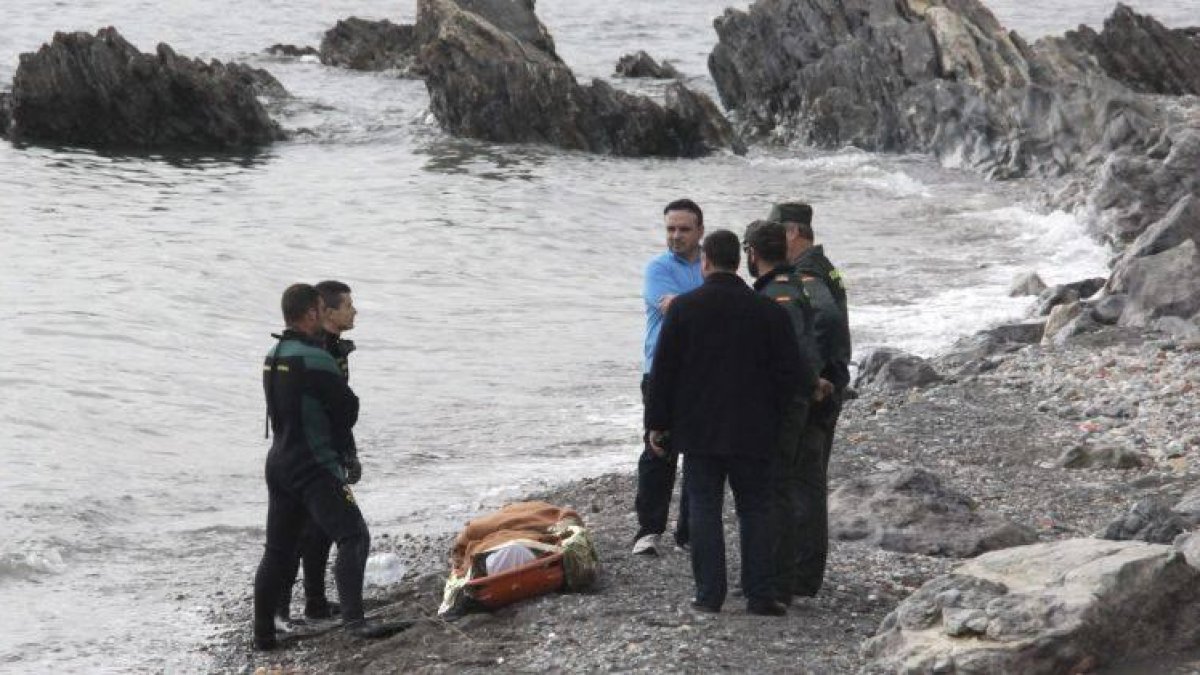 Miembros de la Guardia Civil, junto a uno de los dos cadáveres hallados el sábado en la playa de la Ribera, en Ceuta.-EFE