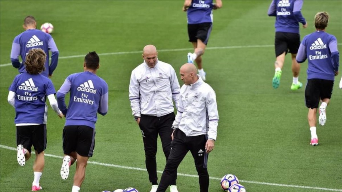 Zidane y su segundo, Bettoni, durante el entrenamiento de este viernes en Valdebebas.-AFP