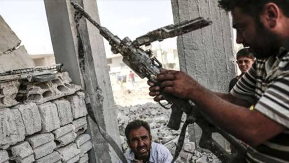 Un hombre con un arma incautada el Estado Islámico en Kobane.-AFP PHOTO/YASIN AKGUL