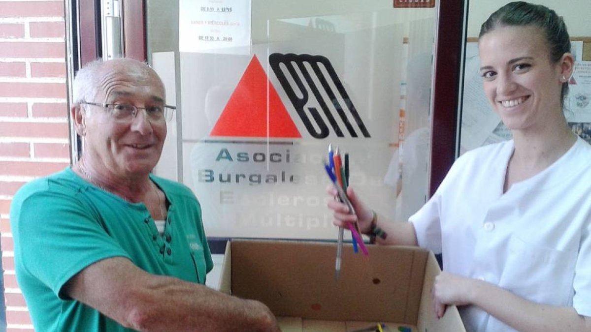 Un voluntario entrega al personal de Asbem parte de los bolígrafos y material de escritura recolectados para la campaña.-ECB
