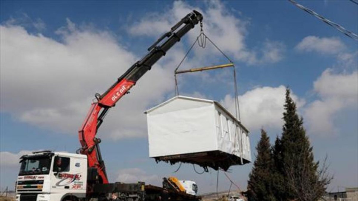 Una grúa levanta, ayer, una casa prefabricada del asentamiento de Amona, desmantelado por Israel.-AFP / THOMAS COEX