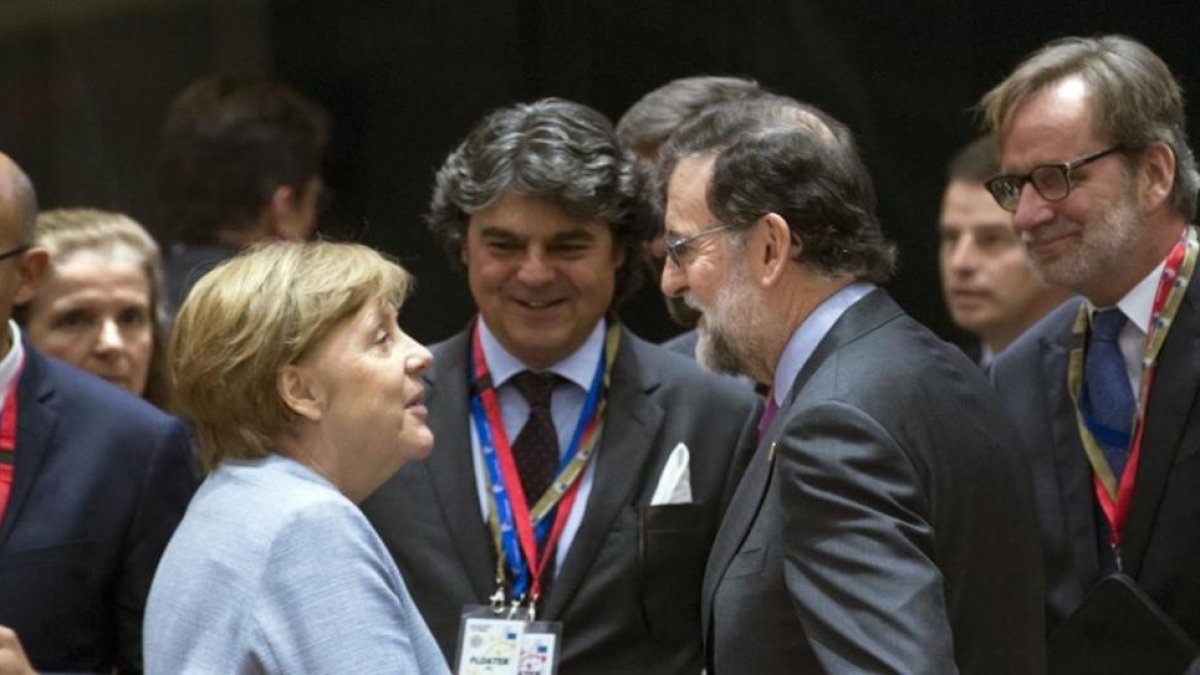 Merkel y Rajoy se saludan antes del comienzo de la cumbre.-EFE