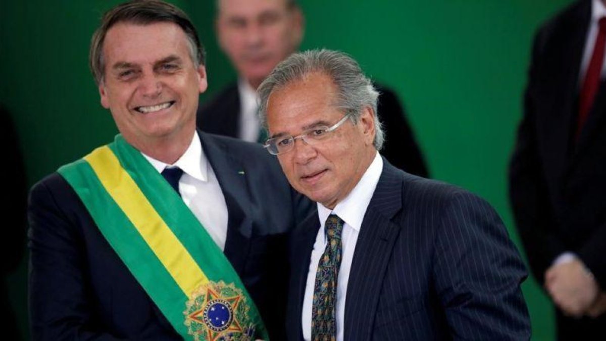 El presidente brasileño, Jair Bolsonaro, junto a Paulo Guedes, ministro de Economía.-UESLEI MARCELINO (REUTERS)