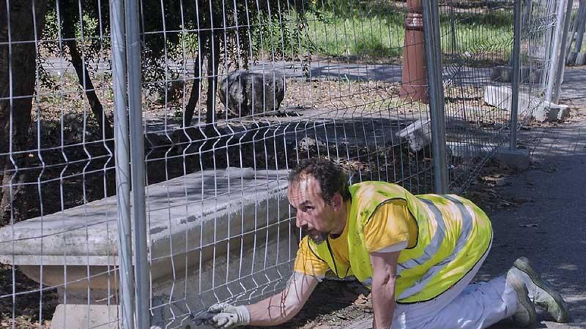 Un operario pintaba uno de los bancos de hormigón en la mañana de ayer.-SERGIO ISAR