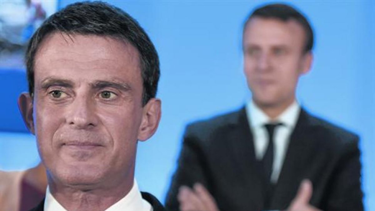 TRASVASE Manuel Valls y Emmanuel Macron detrás, en mayo del 2016.-AFP / PHILIPPE DESMAZES