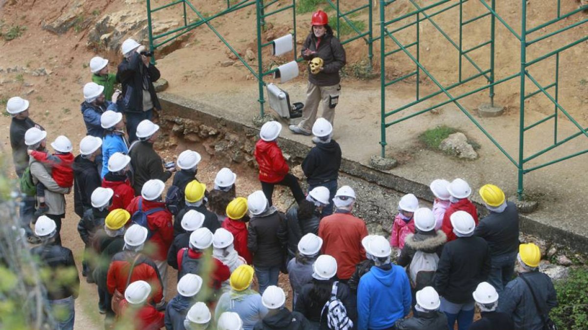 Un grupo de turistas atiende las explicaciones de uno de los guías de Atapuerca.-RAÚL G. OCHOA