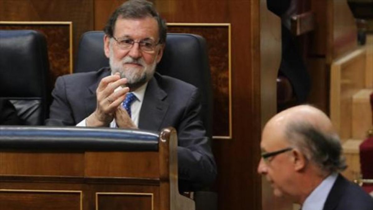 Mariano Rajoy aplaude, el jueves, a su ministro de Hacienda y Función Pública, Cristóbal Montoro.-JUAN MANUEL PRATS