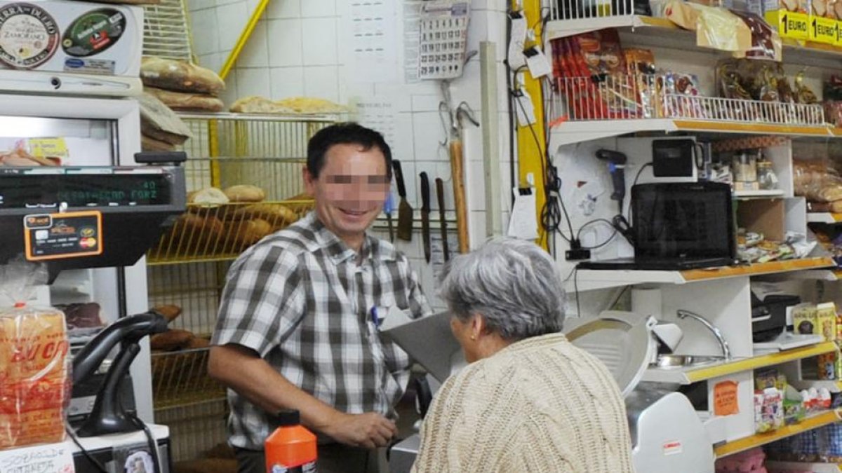 Un hombre atiende a una mujer en su establecimiento.-ISRAEL L. MURILLO