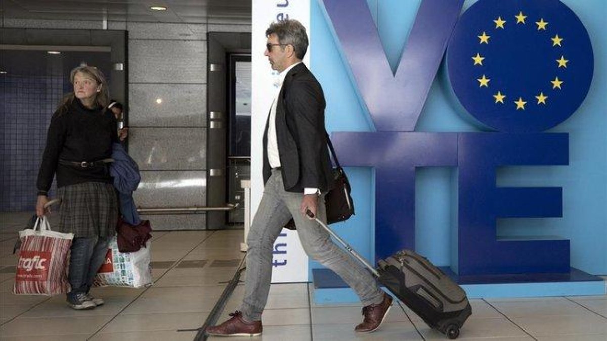 Un hombre pasa junto a un anuncio llamando al voto en las elecciones europeas en el metro de Bruselas, este viernes.-VIRGINIA MAYO (AP)
