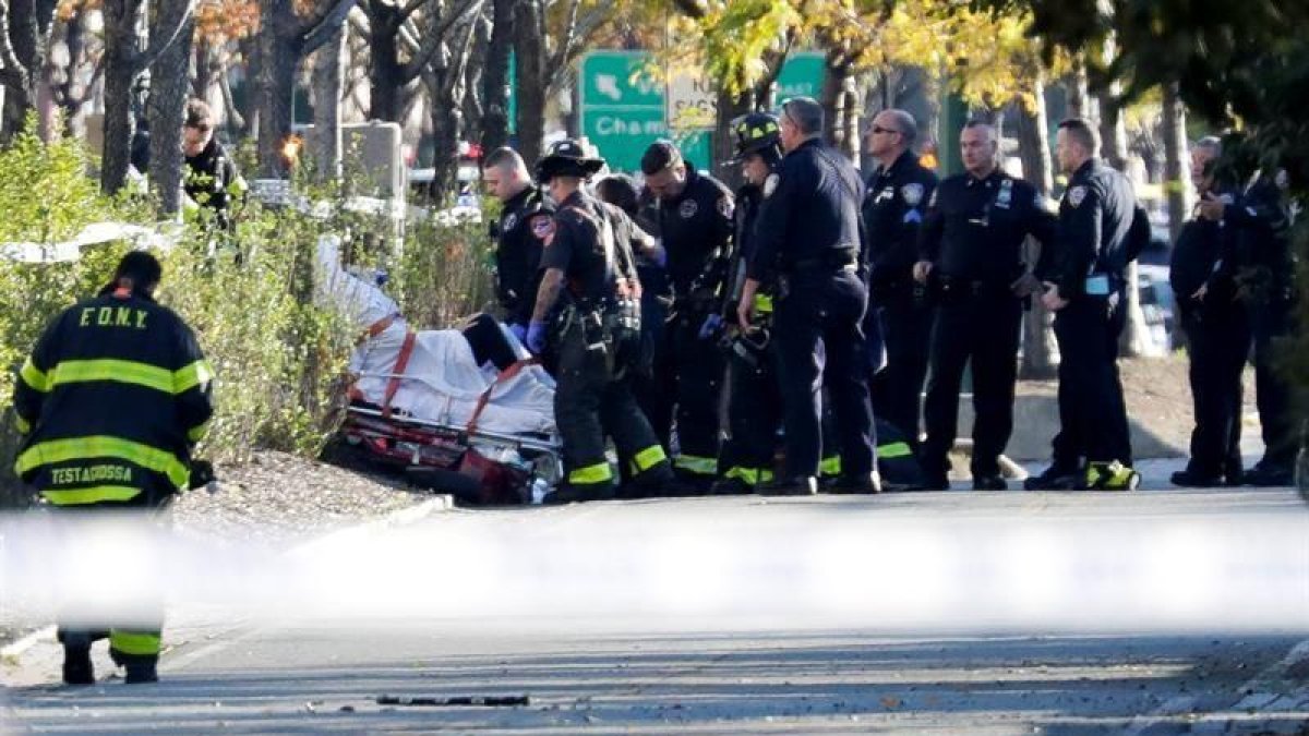 Miembros de la unidad de emergencias retiran el cuerpo de una víctima mortal .-EFE