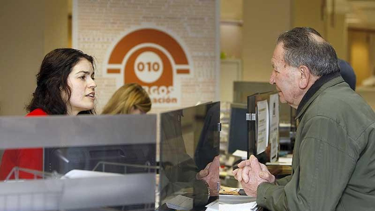 Una trabajadora del 010 atiende a un hombre en el Ayuntamiento de Burgos.-RAÚL G. OCHOA