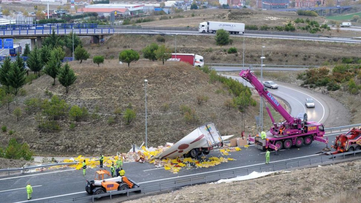 Una grúa de gran tamaño retira el vehículo accidentado en el nudo Landa.-ISRAEL L. MURILLO