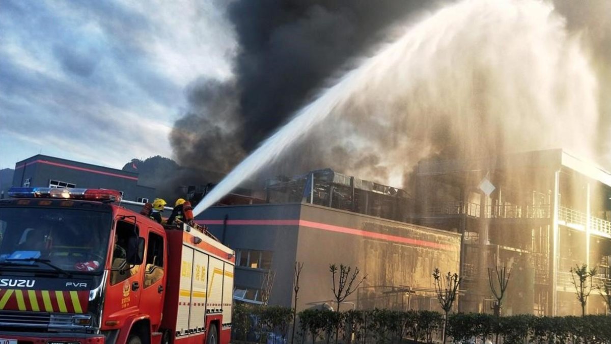 Los bomberos durante las tareas de extinción del incendio, este jueves en China.-/ STR