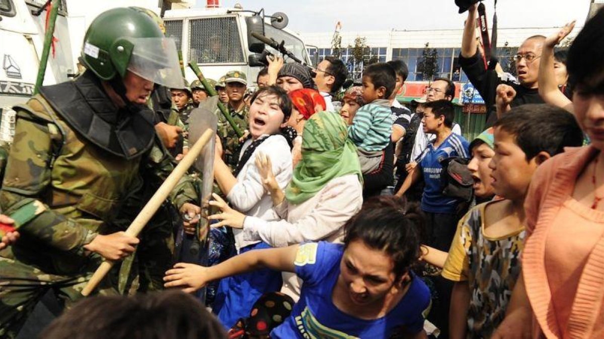 La policía china carga contra una manifestación de uigures en Urumqi, en la provincia de Xinjiang.-PETER PARKS (AFP)