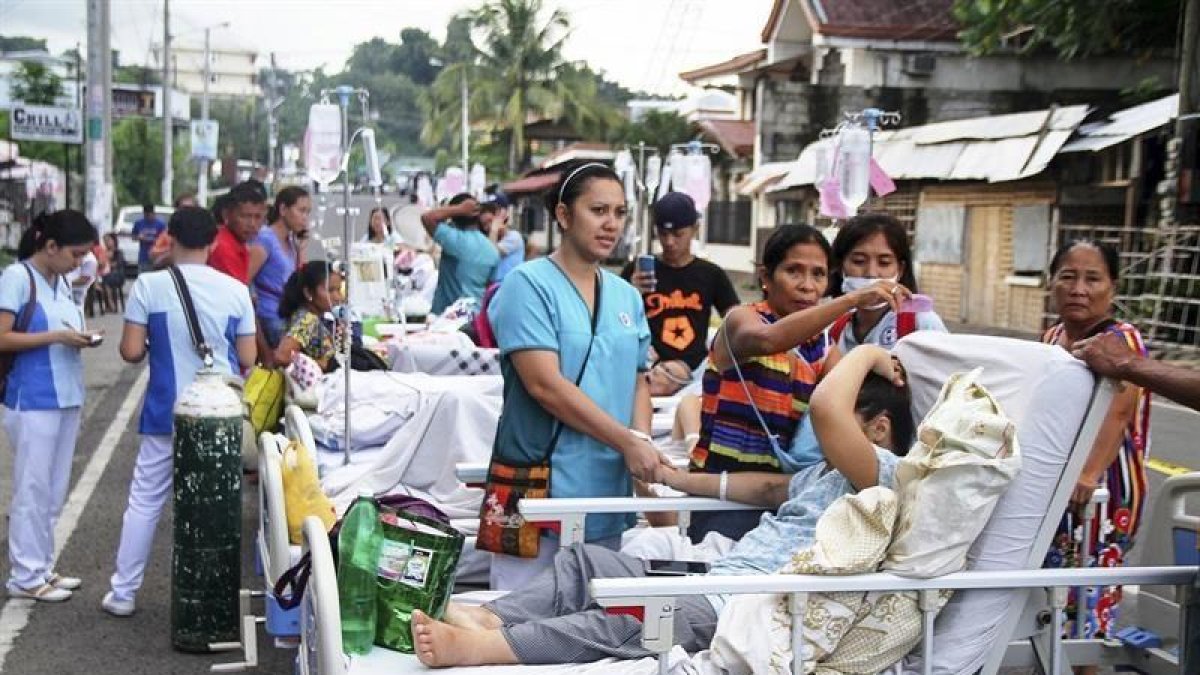 Pacientes y enfermeras permanecen en la calle a las puertas de un centro de evacuación tras un terremoto de 5,1 grados en la escala Ritcher en la isla de Leyte (Filipinas).-EFE / ROBERT DEJON