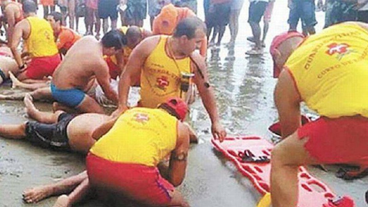 Socorristas reanimando a las víctimas tras la caída del rayo en Praia Grande (Brasil).-Foto: EL HORIZONTE
