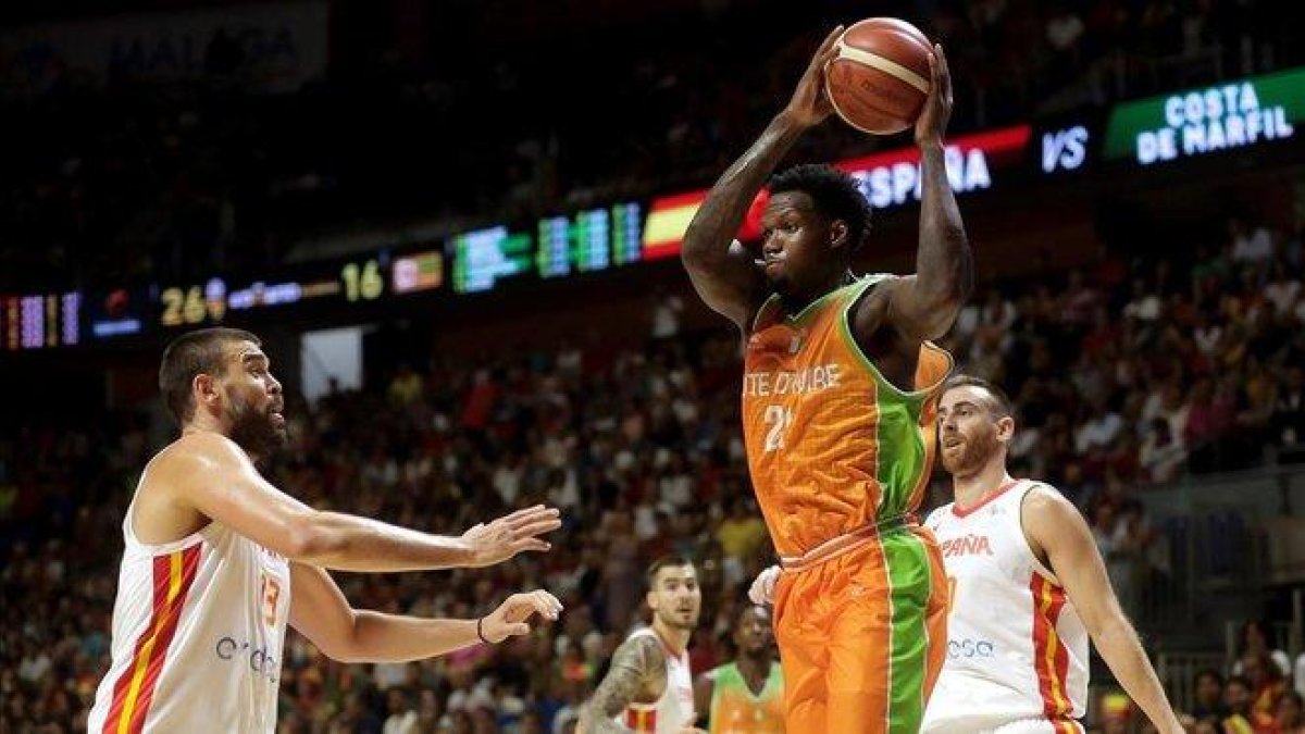 Deon Thompson atrapa un rebote ante Marc Gasol y Víctor Claver.-EFE / / CARLOS DÍAZ