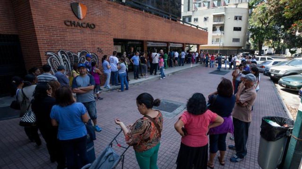 Un grupo de personas hacen cola para comprar medicinas en una farmacia en la ciudad de Caracas (Venezuela).-EFE / MIGUEL GUTIERREZ