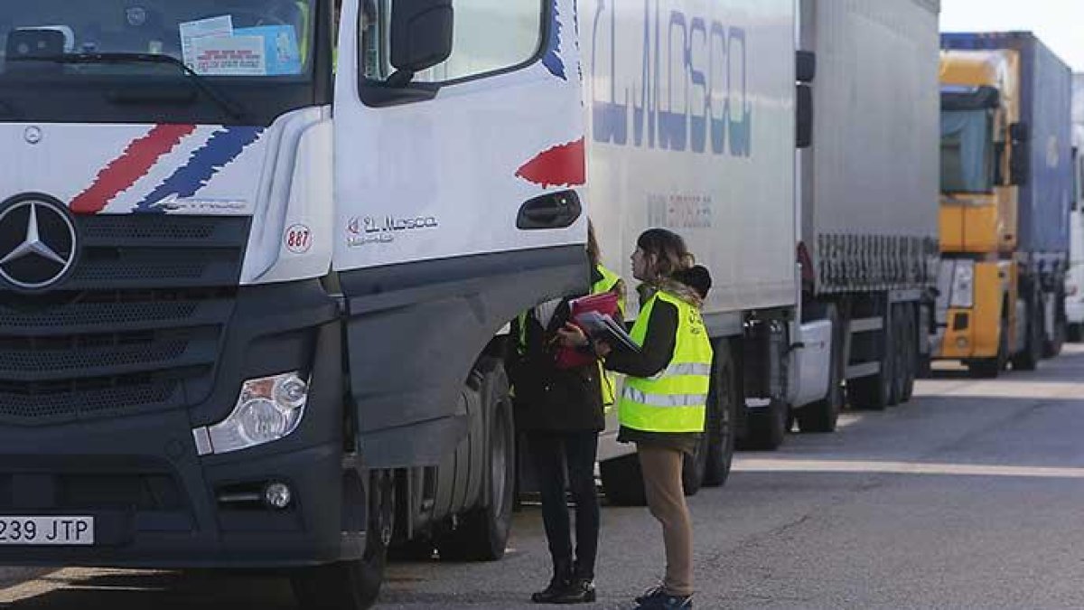 Dos operarias conversan con un transportista en el Centro de Transportes de Burgos.-RAÚL G. OCHOA