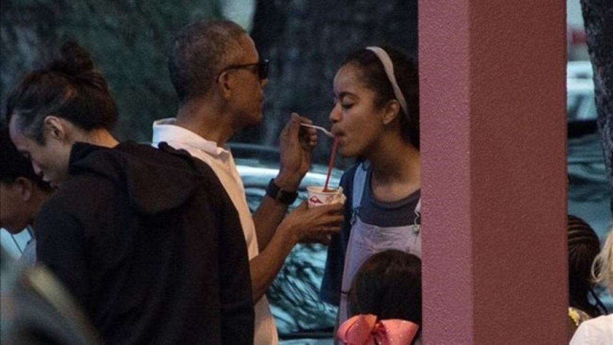 Obama da a su hija Malia un poco de su granizado, la pasada Nochebuena en Kailua (Hawai).-AFP / NICHOLAS KAMM