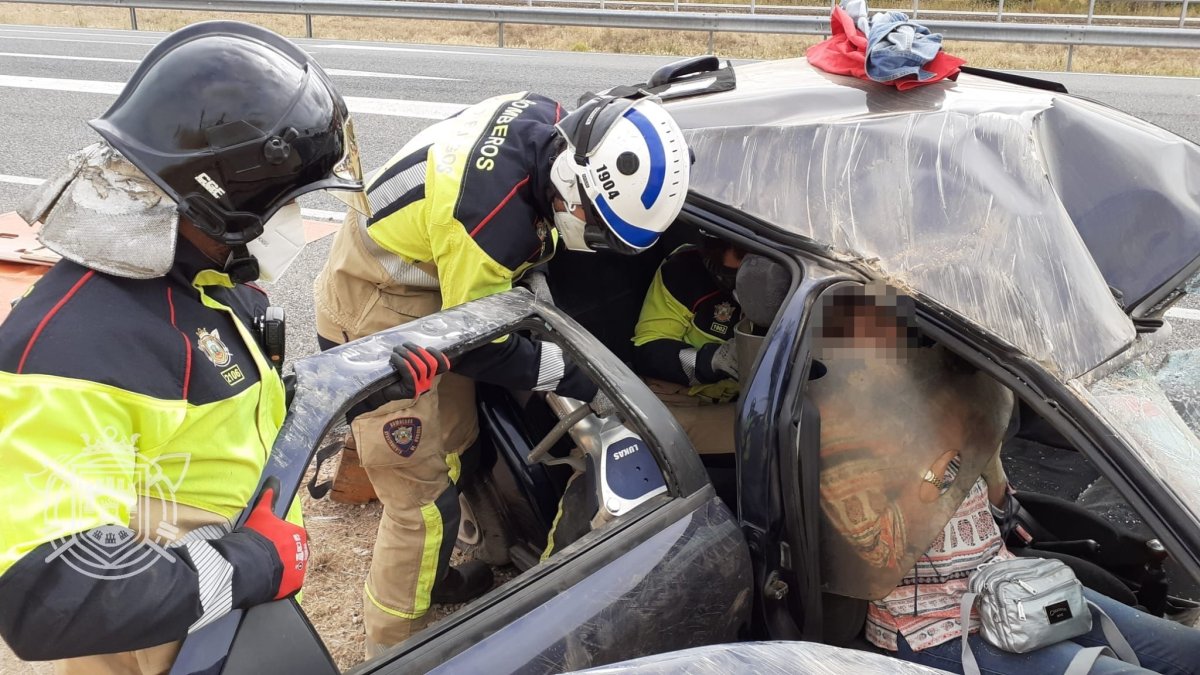 Los bomberos ayudan a extraer a las dos mujeres heridas del coche. BOMBEROS DE BURGOS
