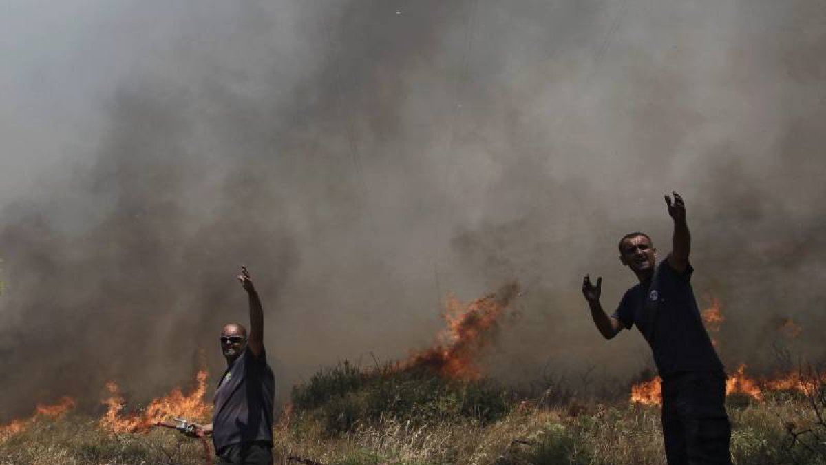 Bomberos tratan de sofocar un incendio en el suburbio de Ilioupoli en Atenas (Grecia).-Foto: EFE