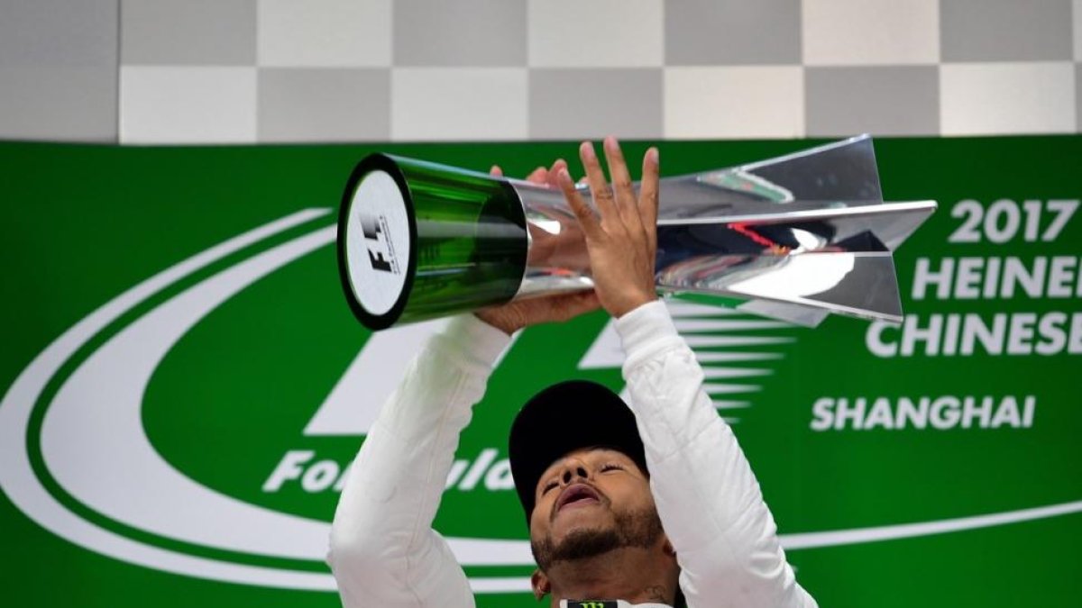 Hamilton, en el podio de Shanghái, tras ganar este domingo el GP de F-1 de China.-AFP