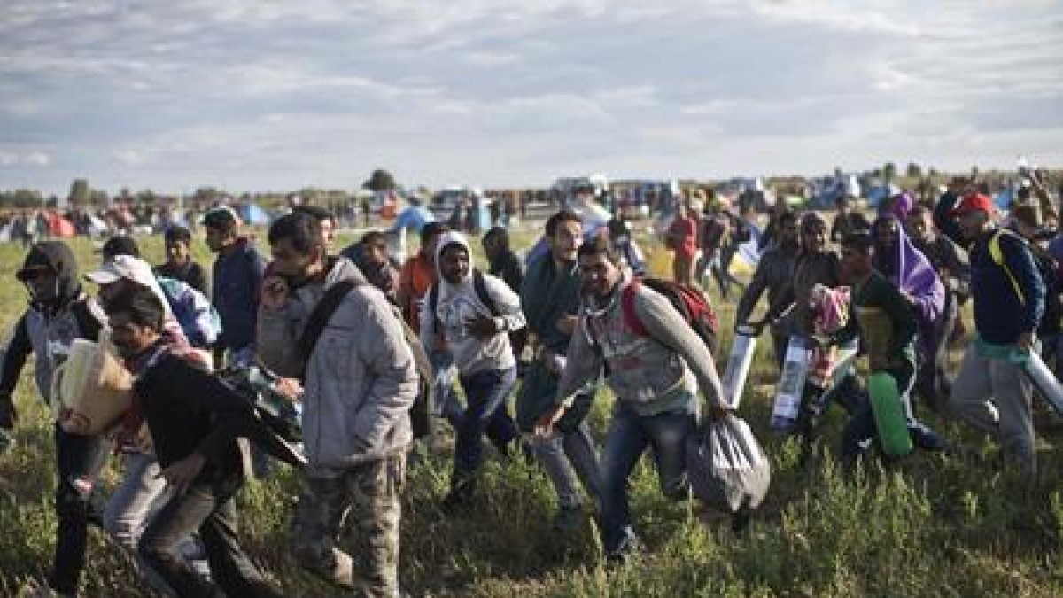 Refugiados a su paso por tierras húngaras, en el 2015.-MARKO DROBNJAKOVIC (AP)