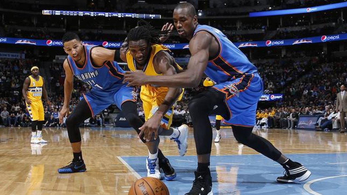Andre Roberson y Serge Ibaka corren por el balón, en el choque entre los Thunder y los Nuggets en Denver.-Foto: AP / DAVID ZALUBOWSKI