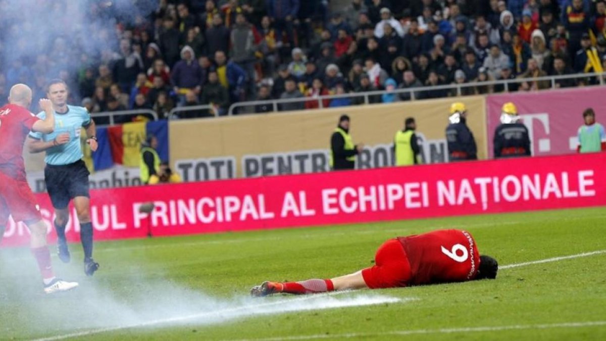 Lewandowski, en el césped tras caer un petardo a su lado en el Rumanía-Polonia.-EFE / ROBERT GHEMENT