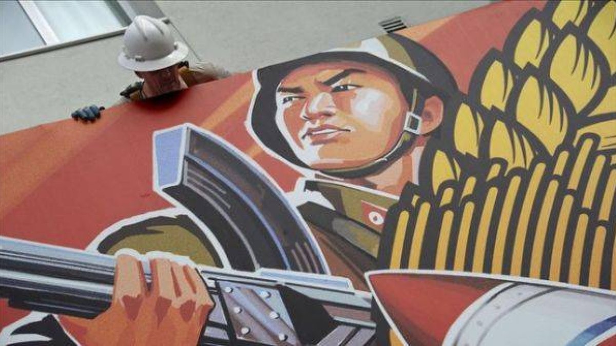 Un trabajador sacando el cartel de 