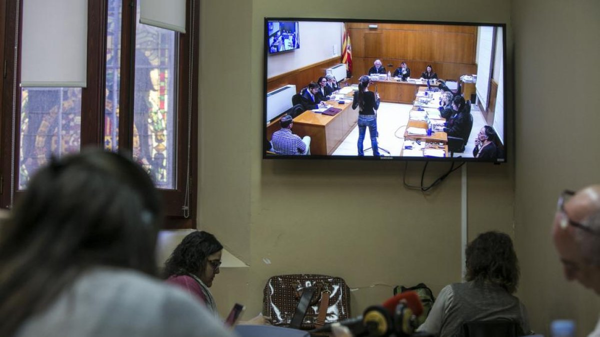 Periodistas siguen la declaración de una testigo por un monitor, en la Audiencia de Barcelona.-JOAN PUIG