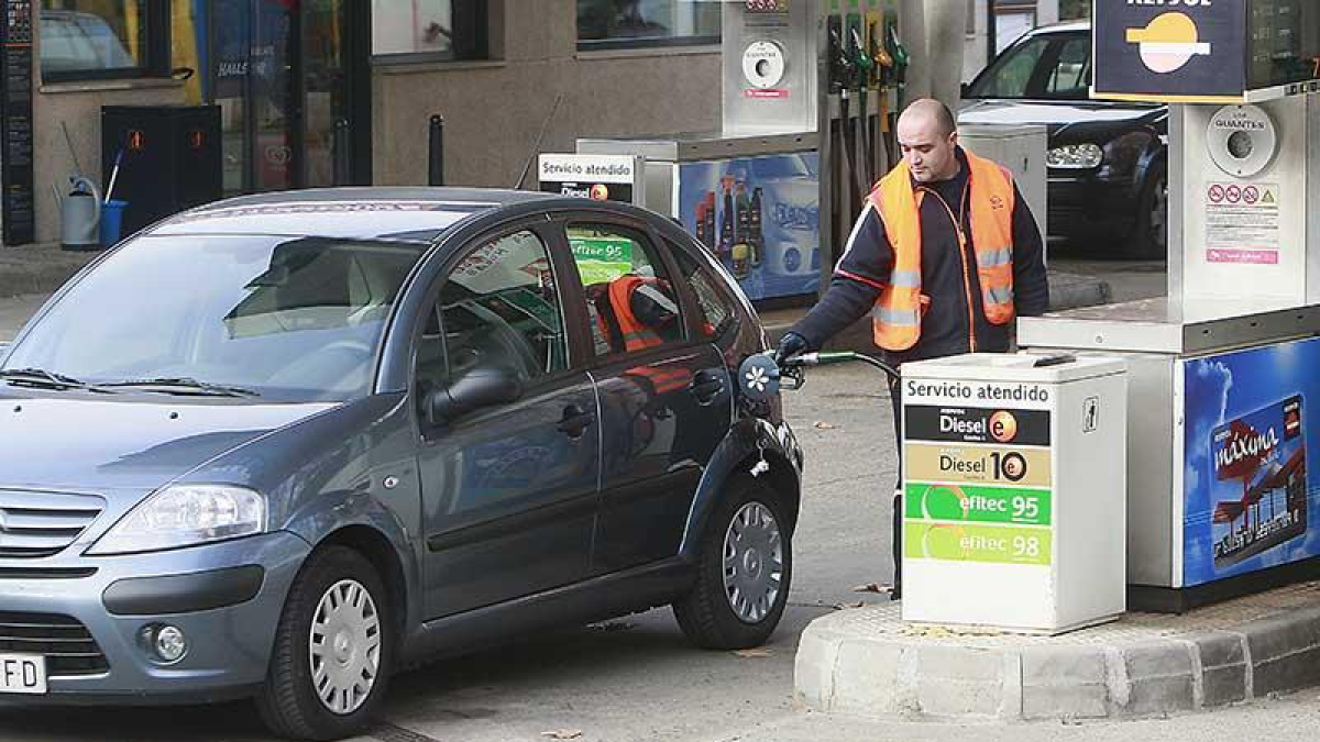Un empleado de gasolinera echa combustible en un vehículo.-RAÚL G. OCHOA