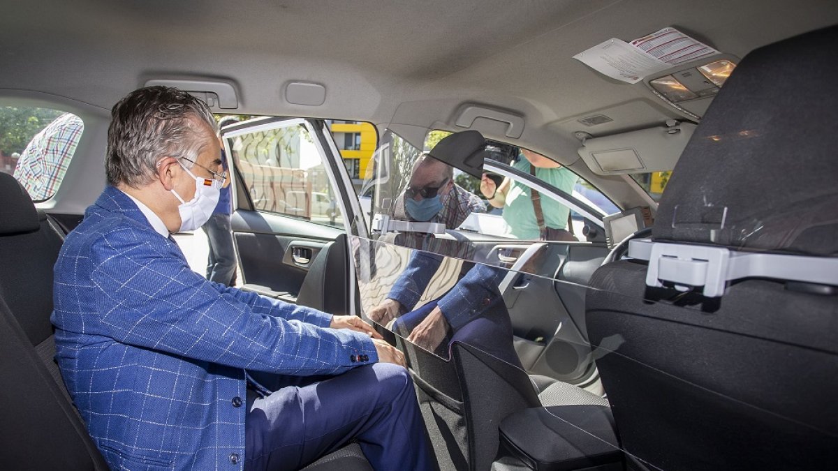 El delegado de la Junta, Roberto Saiz, inspecciona una de las mamparas que entregó ayer tras ser instalada en un taxi. SANTI OTERO