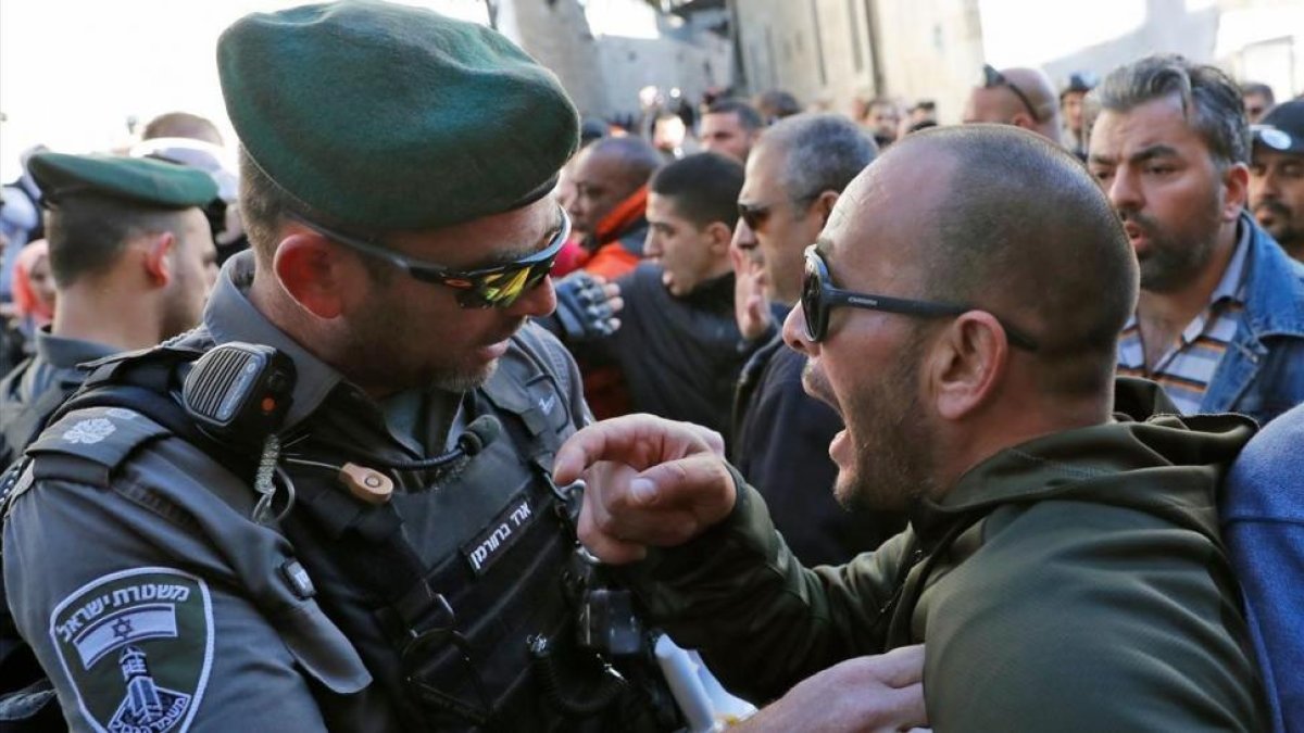 Un palestino se enfrenta a un policía israelí en Jerusalén.-THOMAS COEX / AFP