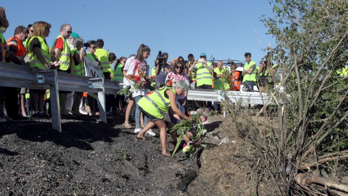 Una integrante de la plataforma de afectados por la N-I deja un ramo de flores en el lugar del último accidente mortal.-G.GONZÁLEZ